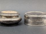 pair of silverplated containers with lids on a gray surface
