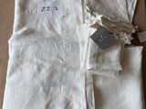 une pile de linge de maison blanc plié posée sur une table en bois