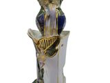 a figurine of a woman sitting on a vase