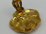 a close up of a gold plated object on a white surface
