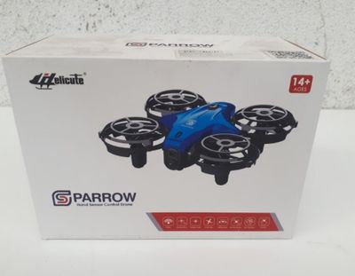 the box is open on a white table with a blue drone in it