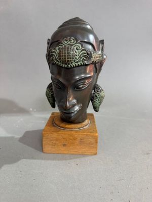 une image représentant la tête d'une femme sur un socle en bois
