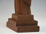 a wooden statue of a man holding a book