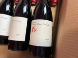 three bottles of wine are sitting in a box on a table