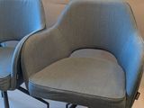 pair of mid - century style chairs with black metal legs and a blue upholstered seat