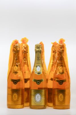three bottles of champagne are lined up on a white surface