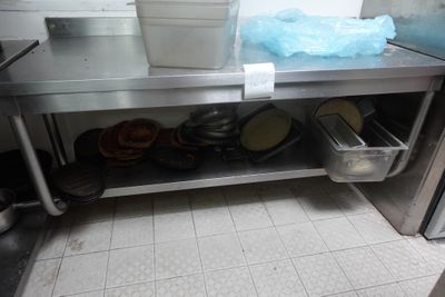 un plan de travail en acier inoxydable sur lequel sont posés des casseroles et des poêles