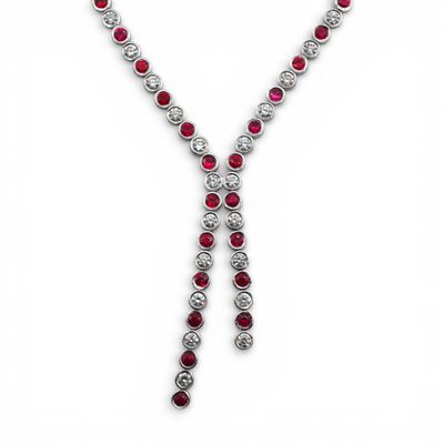 un gros plan d'un collier de diamants et de rubis sur fond blanc