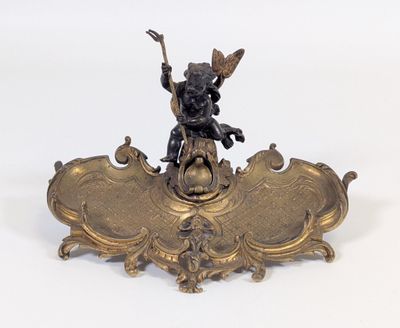 une statue en bronze représentant un garçon debout sur un bouclier