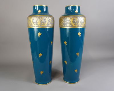 une paire de vases bleus ornés de motifs dorés sur fond gris