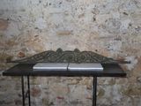 a small table with a book on it in front of a brick wall