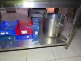 a large pot on a metal table next to crates on the floor