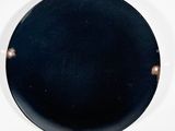 a black plate with rivets on it on a white surface