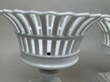 two white vases that are sitting on a table