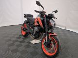a black and orange motorcycle parked on a black and white checkered floor
