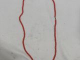 un collier de perles rouges orné d'une petite perle rouge
