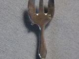 a silver fork with a metal handle on a gray cloth