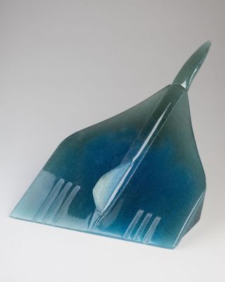 a blue glass sculpture of a plane on a white surface