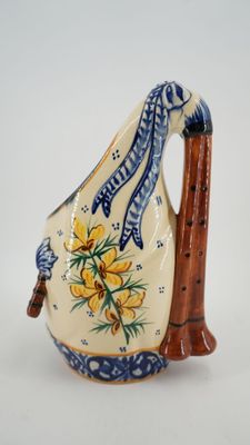 a small ceramic pitcher with a handle and flowers on it