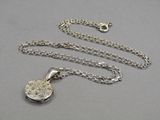 a close up of a necklace with a chain on a table
