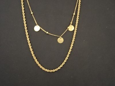 un gros plan d'un collier orné de pièces de monnaie sur fond noir