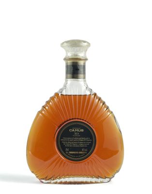 une photo d'une bouteille de brandy posée sur une surface blanche