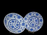 two blue and white plates with floral designs on them