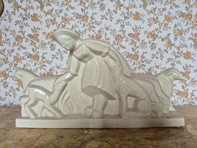 une sculpture blanche représentant un cheval et un chien, posée sur une table