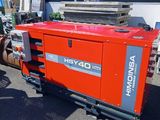 an image of a man standing next to a large red machine