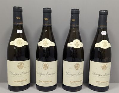 quatre bouteilles de vin sont alignées sur une table