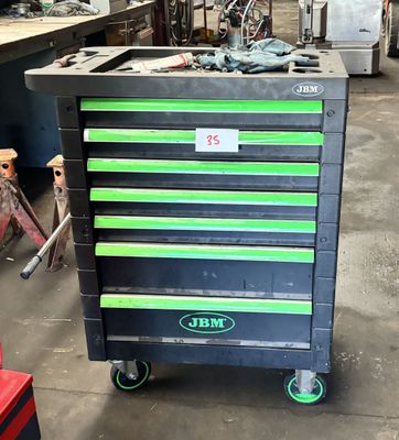 un chariot à outils noir et vert dans un garage