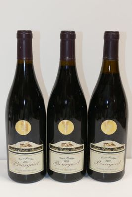 trois bouteilles de vin posées sur une table, l'une à côté de l'autre