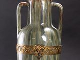 a green vase with a gold decoration on it