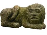 a stone statue of a man laying down on the ground