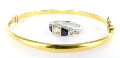 an image of a gold bang bracelet with a sapphire and diamond ring