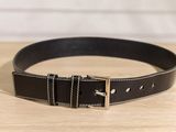 a close up of a black leather belt on a wooden table