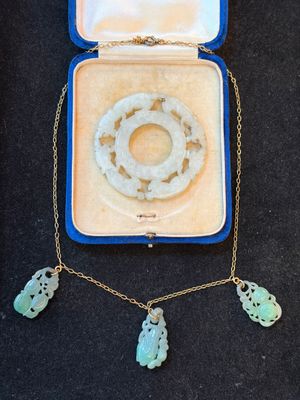 an open box with a necklace and two charms in it