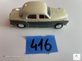 une petite voiture posée à côté d'une feuille de papier