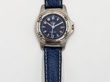 une image représentant une montre avec un bracelet bleu sur un fond blanc