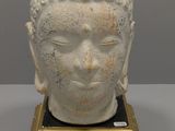 une image représentant une statue représentant une tête de Bouddha posée sur un socle