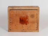 an old wooden box with a hole in it on a white surface