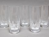 four clear glasses are lined up in a row on a white surface