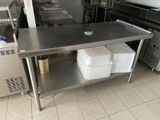 une table de travail en acier inoxydable sur laquelle se trouvent tout un tas de plats