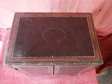 an old wooden box sitting on top of a pink blanket