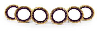 quatre assiettes dorées et violettes, bordées de noir, sur un fond blanc
