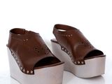 une paire de chaussures marron posées sur une surface blanche