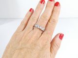 a woman ' s hand with a diamond ring on it