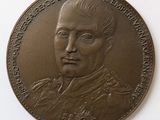 an old bronze medal with a portrait of a man in a military uniform