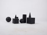 Plusieurs formes géométriques noires sont disposées sur une surface blanche