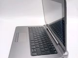 a silver laptop with a black keyboard on a white surface